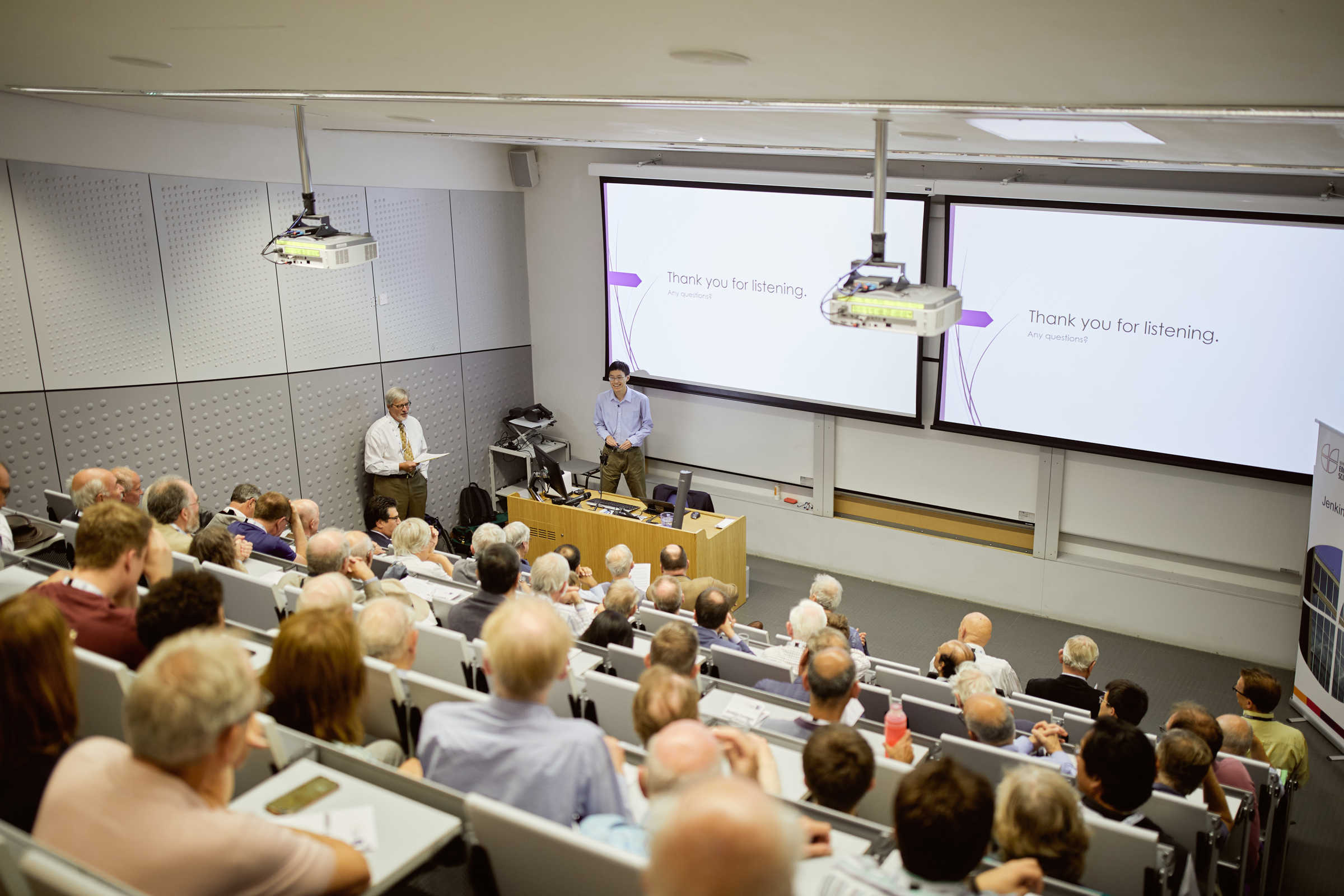 Wide view of a lecture hall filled with attendees listening to a presenter in Engineering Science.