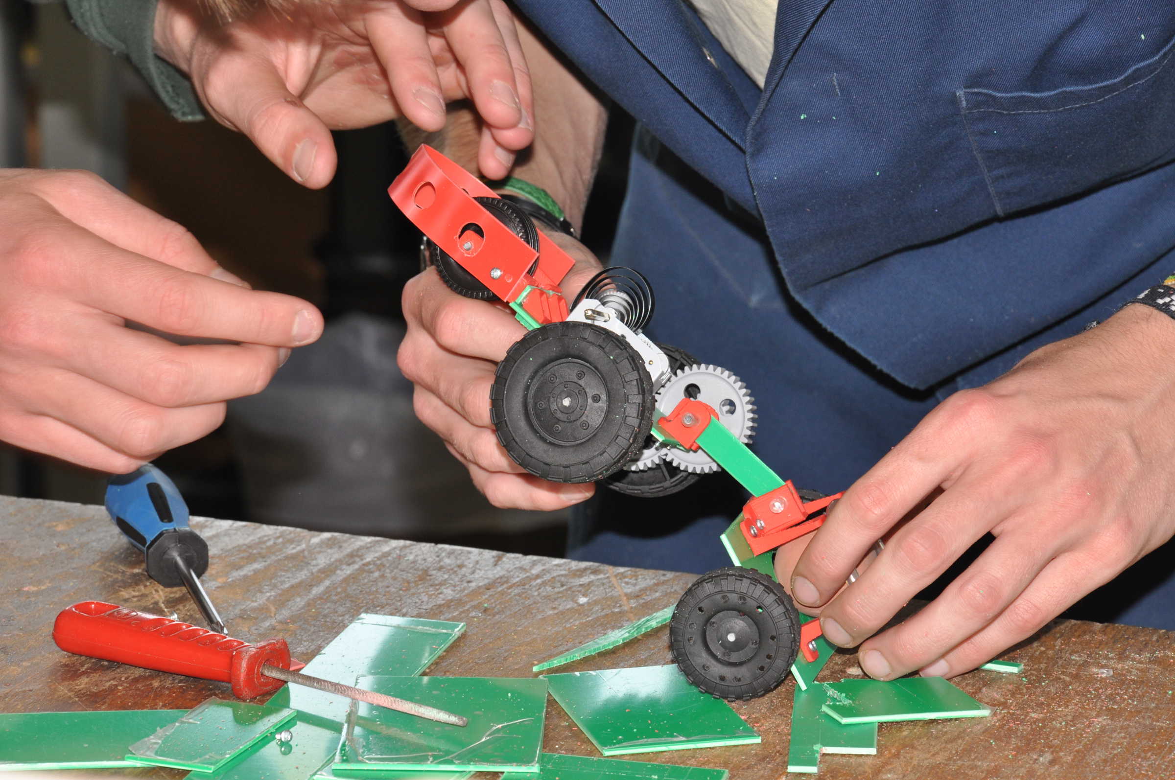 Close up of student hands working with small wheelie car