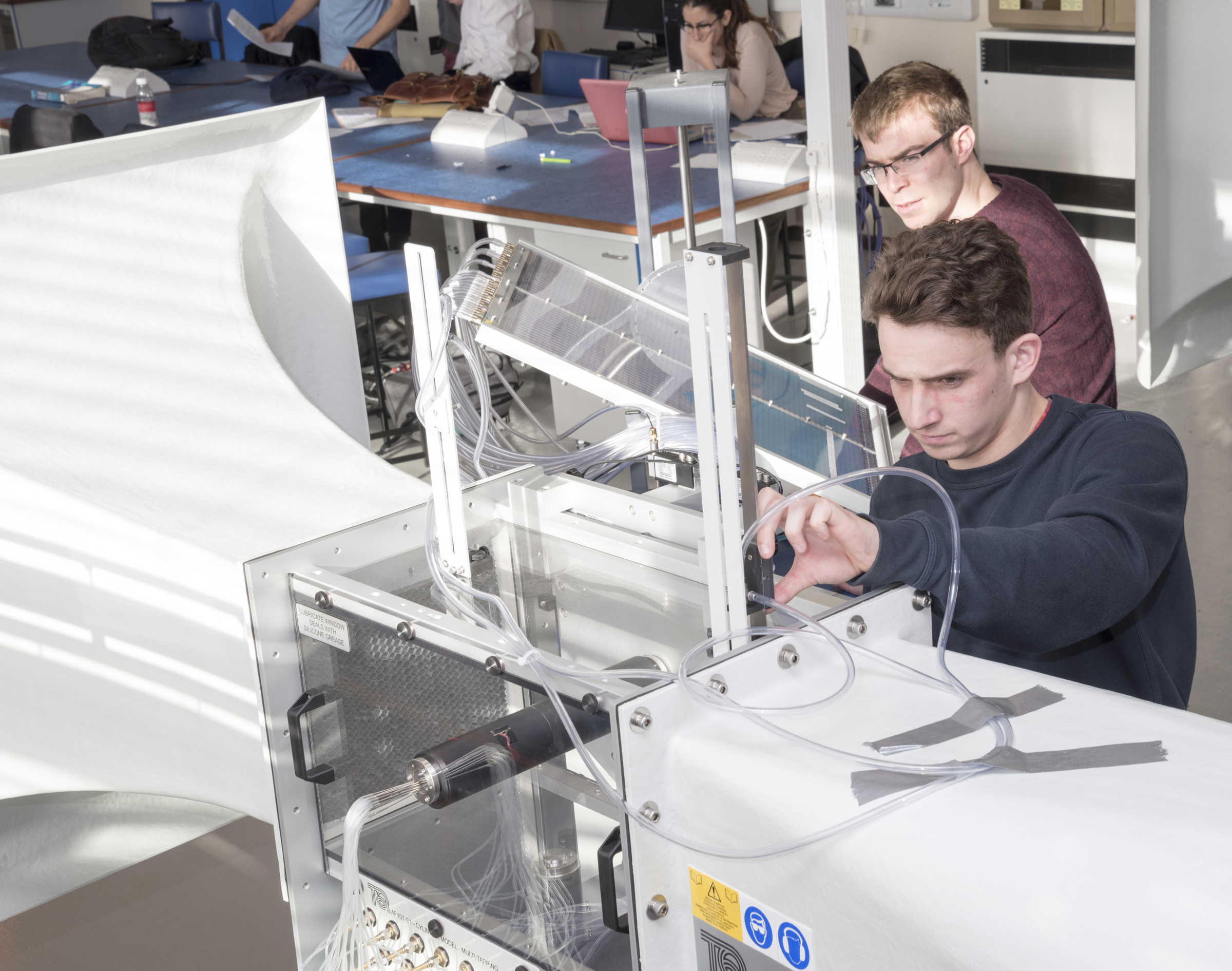 Two students working on wind tunnel machine