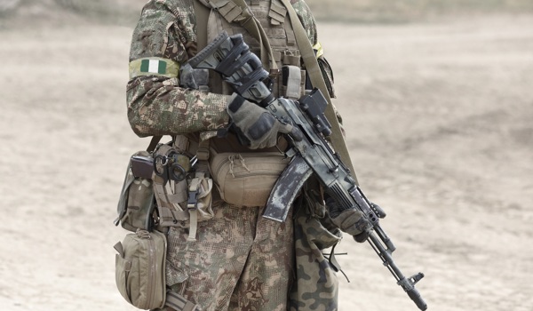 Soldier with machine gun and flag of Nigeria on military uniform