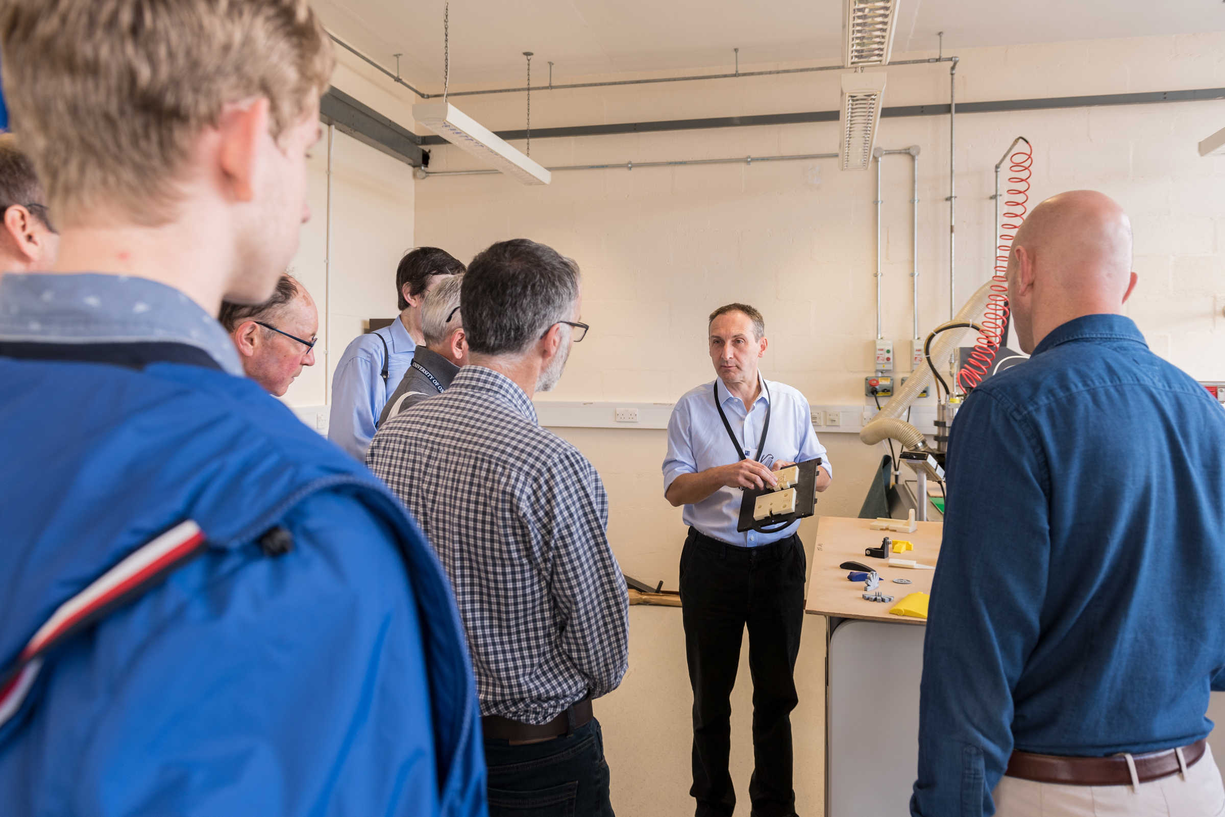 Man talking to a group of people in a workshop