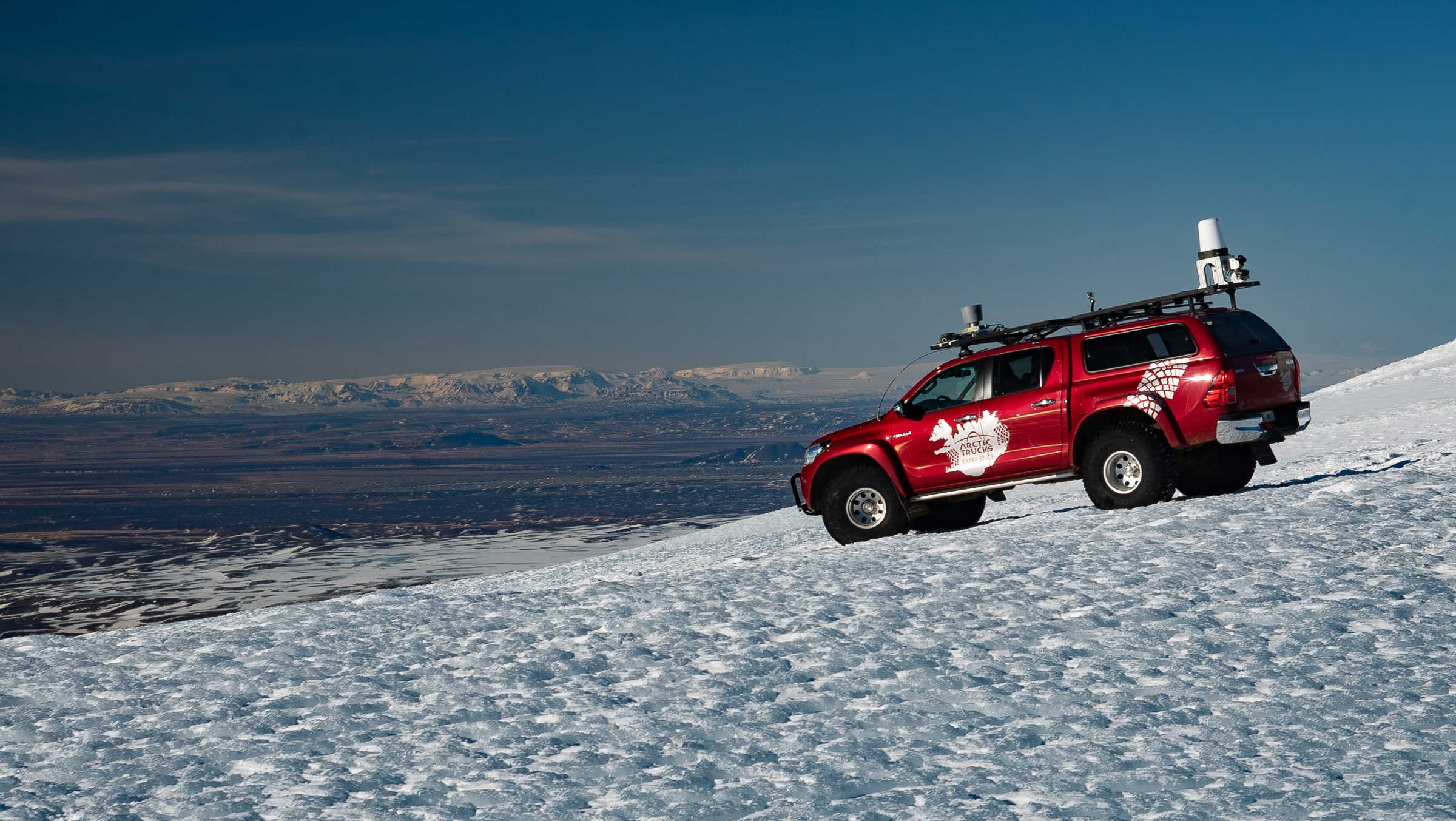 Red vehicle on glacier in Iceland for trails. 