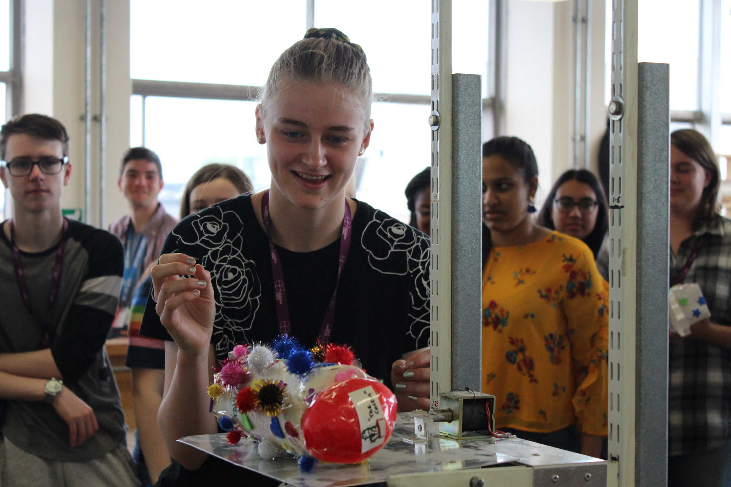 School student places handmade project on scales infront of classmates
