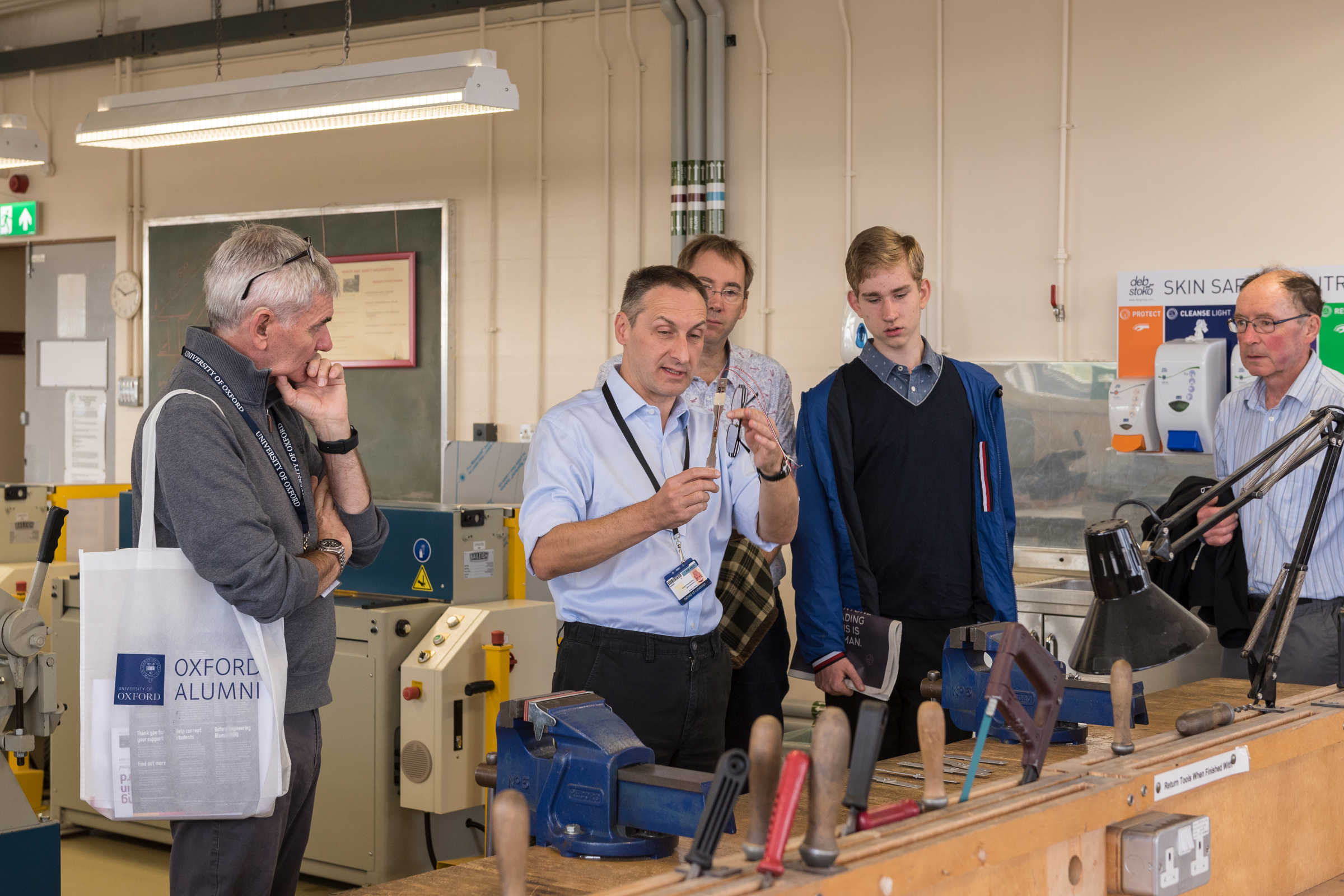 Man demonstrating in lab to group of men