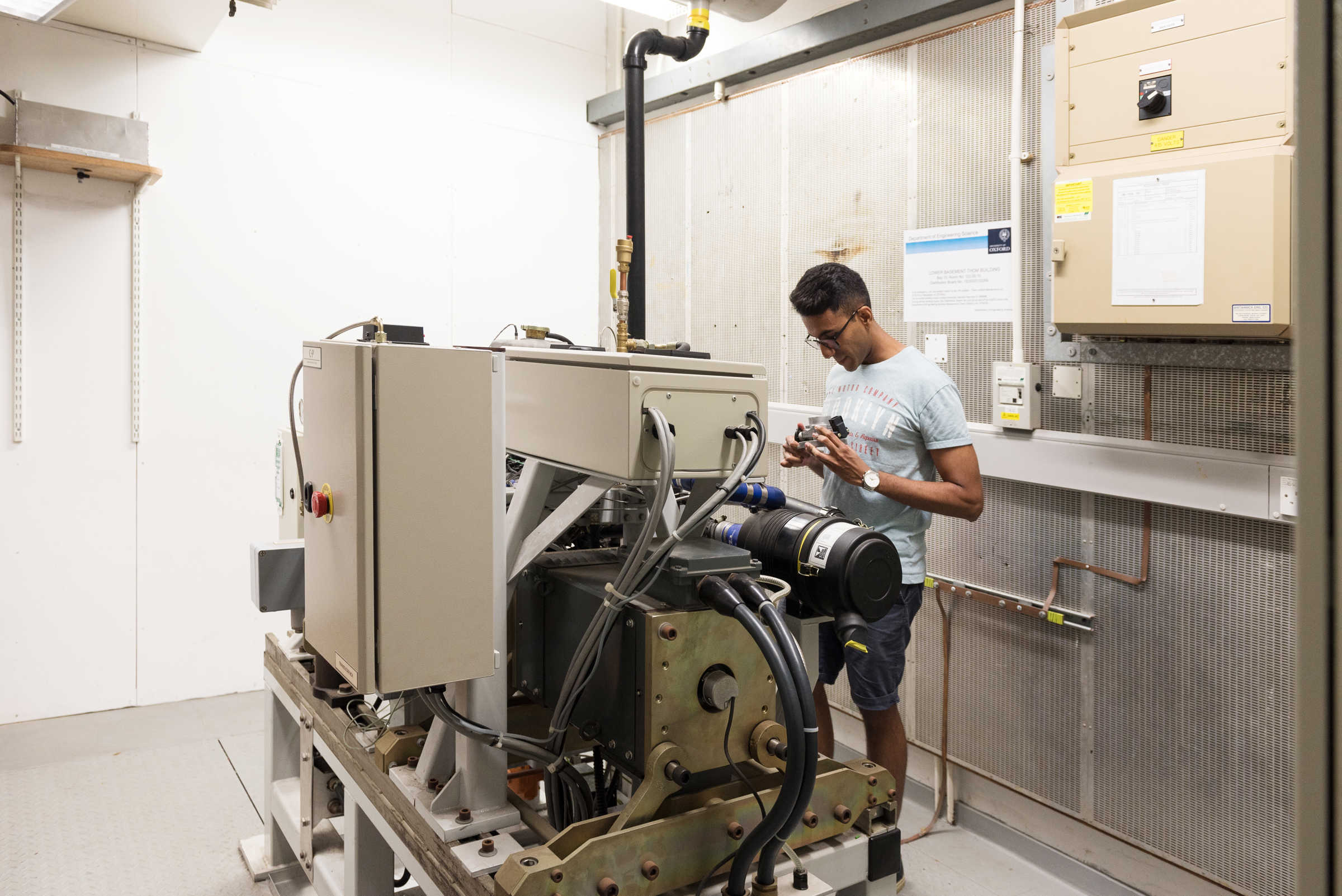 Student working on a machine at the centre of a large room