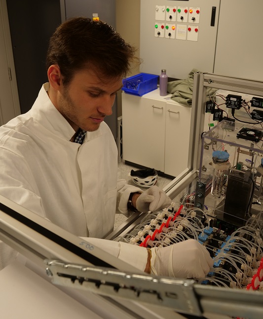 DPhil Student works on machine in a lab