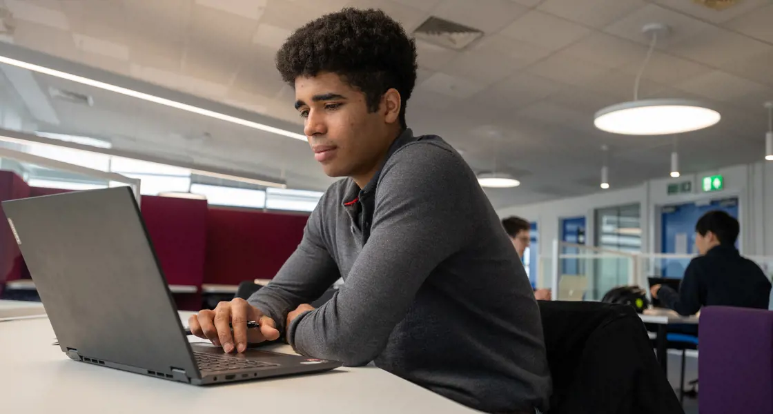 Engineering student working at laptop in student study area